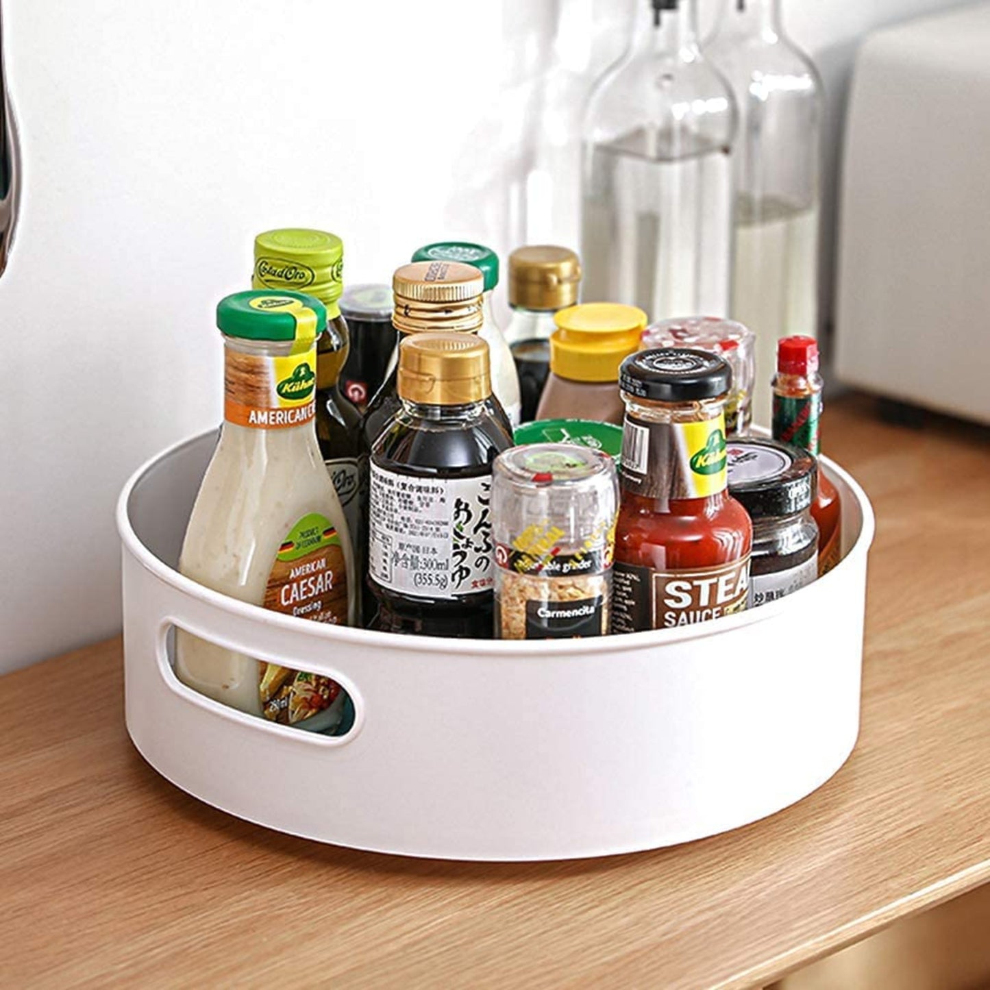 White plastic tray holding various condiment bottles on a wooden surface.