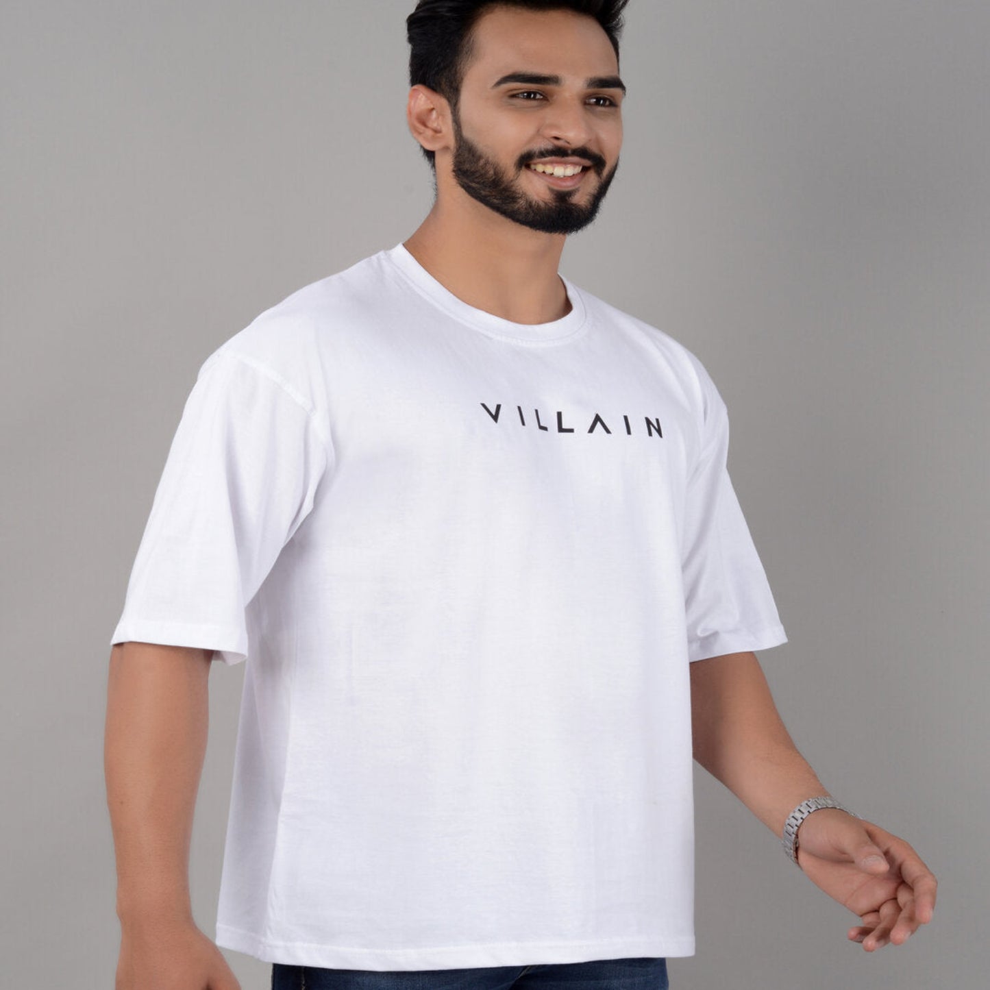 Man wearing a white t-shirt with 'VILLAIN' text on a gray background