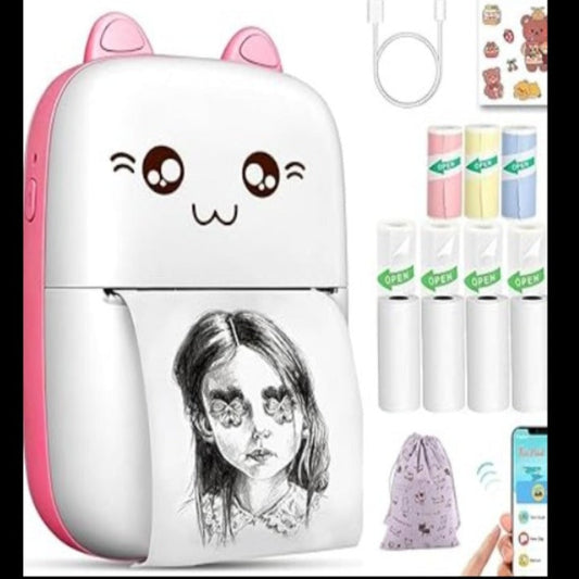 Cute cartoon-style portable device with a person's face printed on it, surrounded by small items.