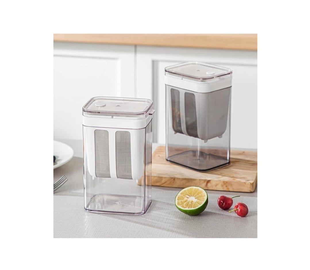 Two clear kitchen storage containers on a countertop with fruits and a cutting board.