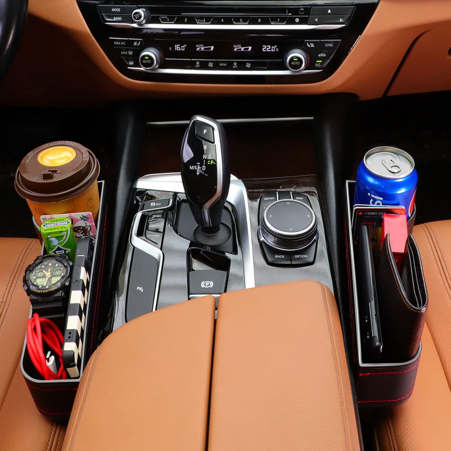 Car interior with cup holders containing a coffee cup, can, and other items.